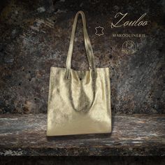 Iridescent leather tote bag iridescent brushed split leather Dimensions: L32 * H33 * D12 cm Lining: 100% synthetic A removable inner pocket of 22 X 16 cm Closure: magnet Height handle in cm: 26 Metallic Leather Bag With Dust Bag Included, Modern Gold Shoulder Bag With Large Capacity, Gold Double Handle Bag With Dust Bag, Gold Soft Leather Shopping Bag, Gold Soft Leather Rectangular Shoulder Bag, Metallic Leather Tote Bag, Gold Leather Tote Shoulder Bag, Gold Leather Shoulder Bag Large Capacity, Modern Gold Tote Shoulder Bag