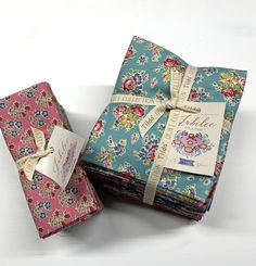 two folded gift boxes with tags on them