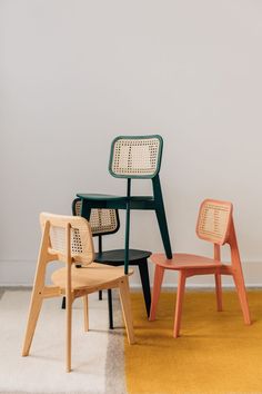 four different colored chairs in front of a white wall with the word favor on it