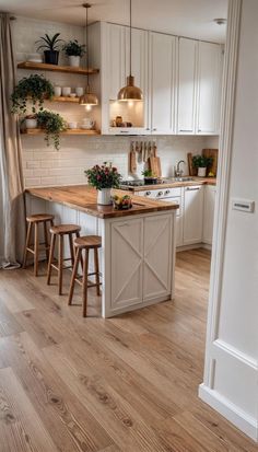 an open kitchen with white cabinets and wooden counter tops, along with two stools