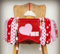 a wooden chair with red and white polka dot fabric on it, decorated like a heart