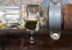 an old pipe with some rust on it and water dripping from the top to the bottom