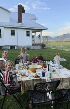 a group of people sitting around a table outside