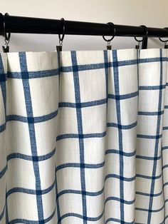 blue and white checkered curtains hanging on a black rod