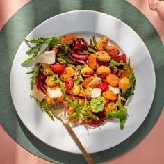 a white plate topped with lots of food on top of a green and pink table