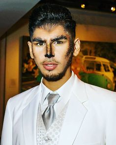 a man in a white suit and tie