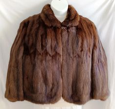 This sale is for a gorgeous dark brown/ mahogany color mink fur cape/stole, open front style.  It features:  *Fully lined with dark brown Bemberg lining  *Flat or Stand Collar * Hands-free fitted shoulder design with inner shoulder straps   * Side slits for arm movement  * Dual seam pockets at waist   * 3 set hooks and eyes front closure. Made by Anni's Furs New York Detroit.  No size label.  I think it would fit L, but please check the measurements (done while flat): *16 inches through the shou Mink Stole, Bridal Bolero, Fur Cape, Fur Coat Vintage, Mahogany Color, Women Outerwear, Fur Stole, Weather Wear, Vintage Fur