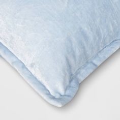 a blue pillow on a white surface with a light blue cover over the top and bottom