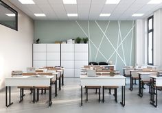 an empty classroom with desks and books on the tables in front of large windows