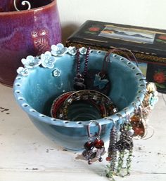 a blue bowl sitting on top of a wooden table next to a vase and other items