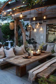 a wooden table sitting on top of a patio next to a white couch and potted plants