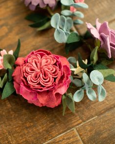 some pink and purple flowers sitting on top of a wooden table