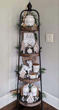 a tiered shelf with christmas decorations and candles on it in front of a wall