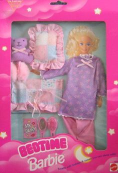 the barbie doll is in its pink box with her clothes and hairbrushes on it