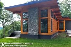 a modern house with wood and stone on the front porch, surrounded by green grass