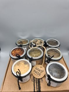 an assortment of spices and seasonings in small containers on a cardboard box with string