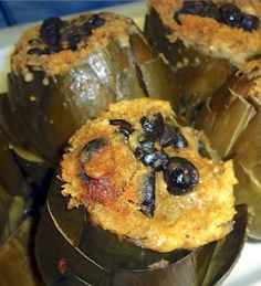 some stuffed green peppers with black olives on top are sitting on a white plate