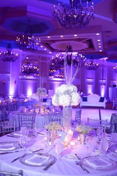 the tables are set with white flowers and candles