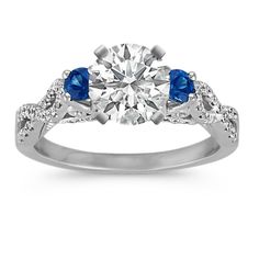 a diamond and blue sapphire engagement ring with two stones on the band, set in white gold