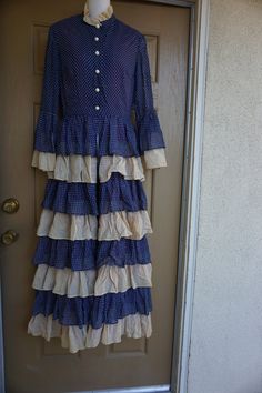 "Vintage dress by Miss Melinda. Labeled size 12. Has unique split front and ruffled skirt. Great vintage condition! Measurements taken across front lying flat 18\" armpit to armpit 14\" across empire waist 58\" length shoulder to bottom" Vintage Tiered Ruffled Dresses, Fitted Polka Dot Maxi Dress With Ruffles, Fitted Polka Dot Ruffled Maxi Dress, Vintage Ruffled Maxi Dress, Vintage Maxi Dress With Ruffles, Fitted Vintage Maxi Dress With Ruffles, Fitted Maxi-length Prairie Dress With Ruffles, Fitted Maxi Prairie Dress With Ruffles, Fitted Prairie Dress With Ruffles In Maxi Length