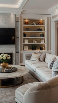 a living room filled with furniture and a flat screen tv mounted on the wall above a fireplace