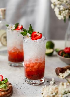 two glasses filled with strawberry mojitas and garnished with fresh mint leaves