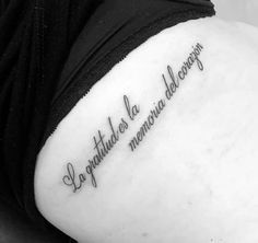 the back of a woman's shoulder with an inscription on it