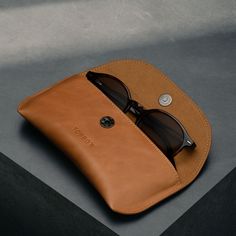 a pair of sunglasses sitting on top of a leather case