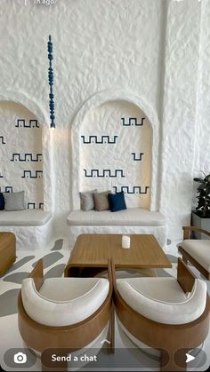 a living room filled with white furniture and blue accents on the walls next to a plant