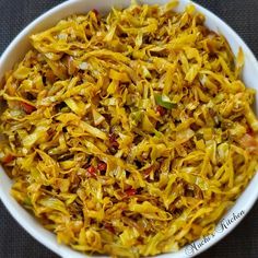 a white bowl filled with yellow food on top of a gray tablecloth covered floor