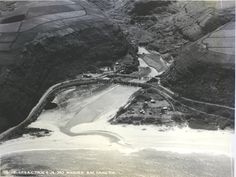 an aerial view of the beach and ocean with houses on it's sides, in black and white