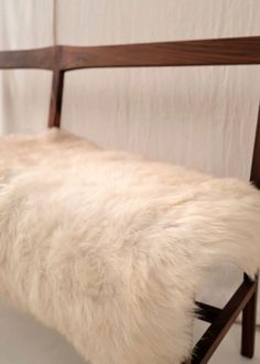 the bench is made out of wood and sheepskin