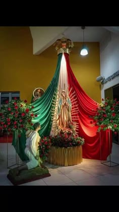 the statue is surrounded by red and green drapes