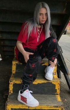 a man with grey hair sitting on steps wearing white sneakers and red t - shirt