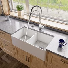 a kitchen sink sitting under a window next to a counter top with a cup on it