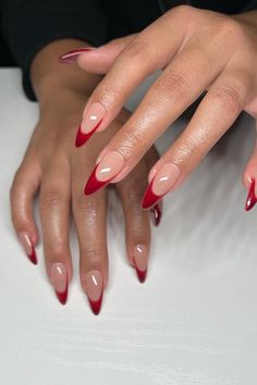 These elegant stiletto nails present a classic French manicure with a twist. The iconic nude base is paired with a bold red tip, creating a striking contrast that's both chic and modern. The flawless execution of color transition makes for a sophisticated and eye-catching look. Perfect for someone who loves a touch of drama while keeping it classy! 💅🌹  // Photo Credit: Instagram @nailzbyrebecca Dark Red Pearl Nails, Red Stiletto French Tip Nails, Red French With Chrome, Red Wine French Tip Nails, Red French Tip Pedicure, Red French Tip Nails Stiletto, Red Almond French Tip, Red French Tip Stiletto Nails, Almond Nails Red French Tip