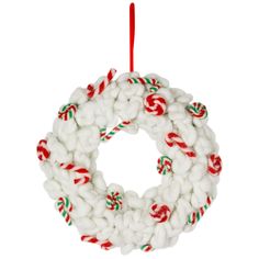 a white christmas wreath ornament hanging from a red and green rope with candy canes on it