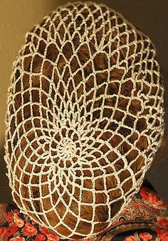 a close up of a woman's head wearing a hat with crochet on it