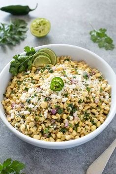 a white bowl filled with corn and topped with cilantro