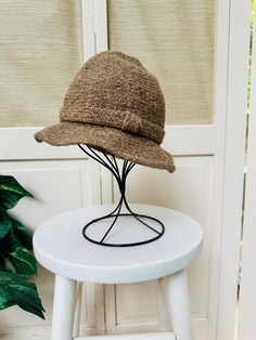 Vintage 40s brown wool/tweed bucket hat.  Made in Italy for Bloomingdales.  50% Wool, 50% Acrylic. Various shades of light brown with a knotted band around the hat.  Interior has a ribbon around the circumference.  In good vintage condition with no stains or holes. Measures approx 20" in circumference. Shipping: USPS Standard Post (insurance tracking included) We are happy to ship internationally! *Due to the variability in shipping costs based on location, anything in excess of $2.00 over the actual cost will be refunded.  We can provide a combined shipping cost and/or estimate to your location. Refunds and Exchanges: All sales are final.  You will not be refunded if an item does not fit. Please check the measurements carefully and ZOOM into photographs to view details.  Please ask any qu Brown Wool Fedora With Curved Brim, Brown Wool Fedora, Brown Wool Cloche Hat With Curved Brim, Brown Wool Cloche Hat With Short Brim, Classic Brown Bucket Hat, Brown Wool Cloche Hat For Winter, Classic Brown Bucket Hat With Short Brim, Classic Brown Wool Cloche Hat, Brown Bucket Hat For Fall