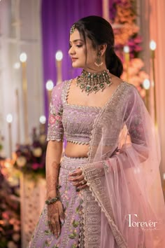 a woman in a purple lehenga and matching jewelry