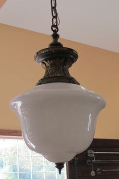 a chandelier hanging from the ceiling in a room with yellow walls and windows