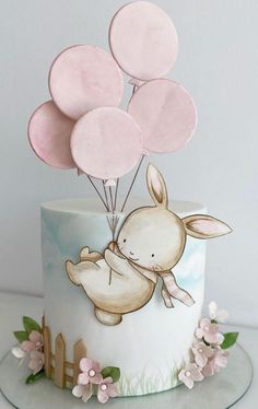 a cake decorated with balloons and an animal