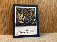 a close up of a christmas card with gold foil on black paper and white background