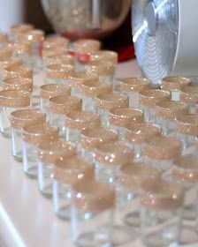 many small cups are lined up on the counter next to a blender and mixer