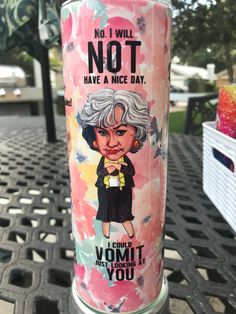 a pink can with an image of a woman on it sitting on a metal table