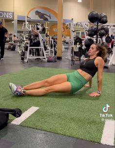 a woman laying on the ground with her legs crossed in front of her, while working out