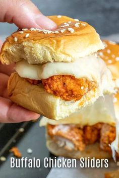 a hand holding a chicken slider with cheese on it and the words buffalo chicken sliders above it