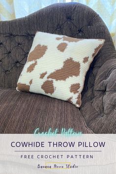 a brown and white cow print pillow sitting on top of a chair