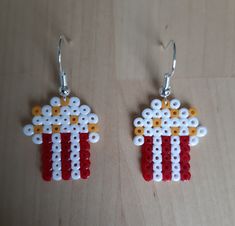 the earrings are made out of legos and have red, white, and yellow beads